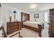 Comfortable bedroom with a dark wooden bedframe and matching dresser at 1465 Via Savona Dr, Henderson, NV 89052