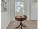 Hallway with decorative table leads to bathroom; neutral interior design featuring tasteful artwork and tiled floors at 1465 Via Savona Dr, Henderson, NV 89052