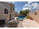 Backyard patio with outdoor seating, grill, built-in pool, hot tub and privacy wall at 1501 Scenic Peak St, Las Vegas, NV 89144
