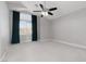 Spacious bedroom with soft carpet, light gray walls, modern ceiling fan, and a window with dark curtains at 1501 Scenic Peak St, Las Vegas, NV 89144