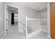 Upstairs hallway with white railing and access to rooms with carpeting at 1501 Scenic Peak St, Las Vegas, NV 89144