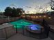 Backyard pool and hot tub with a safety fence, patio, and string lights at 1501 Scenic Peak St, Las Vegas, NV 89144