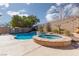 Beautiful backyard with a built-in pool, hot tub, and landscaped area at 1501 Scenic Peak St, Las Vegas, NV 89144