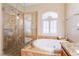 Bathroom featuring a soaking tub and separate glass shower with tiled surround at 1661 Warrenville St, Las Vegas, NV 89117