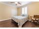 Bedroom featuring warm neutral colors, wood-look flooring, bright natural light, and a ceiling fan at 1661 Warrenville St, Las Vegas, NV 89117