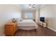 Well-lit bedroom with ceiling fan, wood floors, plantation shutters and TV at 1661 Warrenville St, Las Vegas, NV 89117