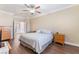 Bedroom featuring warm neutral colors, wood-look flooring, a ceiling fan, and bright natural light at 1661 Warrenville St, Las Vegas, NV 89117