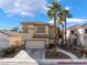 Inviting two-story home featuring a well-manicured lawn, mature palm trees, and attached garage at 1661 Warrenville St, Las Vegas, NV 89117
