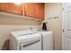 Laundry room features a washer, dryer, cabinets, and hanging rack at 1661 Warrenville St, Las Vegas, NV 89117