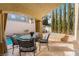 Charming covered patio with dining set, adjacent to a sparkling pool and serene landscaping at 1661 Warrenville St, Las Vegas, NV 89117