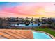 Sunset view of sparkling pool, pond with waterfall, and mountains in the distance at 2221 Glenbrook Way, Las Vegas, NV 89117