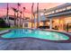Luxury backyard with pool, spa, patio and green lawn at sunset at 2221 Glenbrook Way, Las Vegas, NV 89117