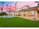 Spacious backyard with lush green lawn and pool at sunset at 2221 Glenbrook Way, Las Vegas, NV 89117