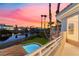 Backyard features pool, lush lawn and views of the water and homes in the distance under a gorgeous sunset at 2221 Glenbrook Way, Las Vegas, NV 89117