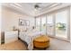 Comfortable bedroom with balcony access, featuring white furniture and a decorative ottoman at 2221 Glenbrook Way, Las Vegas, NV 89117