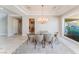 Refined dining room with a chandelier, travertine floors, and a large window overlooking the landscaped yard at 2221 Glenbrook Way, Las Vegas, NV 89117