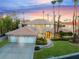 Beautifully landscaped home with a three-car garage and inviting curb appeal enhanced by tall palm trees at 2221 Glenbrook Way, Las Vegas, NV 89117