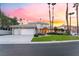 Stunning home with a three-car garage, well-manicured lawn, and lush landscaping at sunset at 2221 Glenbrook Way, Las Vegas, NV 89117
