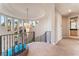 Elegant landing featuring metal and wood railing and curved windows with tropical views and chandelier at 2221 Glenbrook Way, Las Vegas, NV 89117