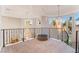 Bright open landing with iron railing, decorative chandelier and views of the property through large windows at 2221 Glenbrook Way, Las Vegas, NV 89117