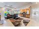 Living room and kitchen with neutral colored walls and floors, modern furniture, and lots of natural light at 2221 Glenbrook Way, Las Vegas, NV 89117