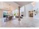 Open-concept living area with a fireplace, elegant dining set, travertine floors, and views of the pool area at 2221 Glenbrook Way, Las Vegas, NV 89117