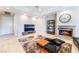 A modern living room features a stone fireplace, dark sofa, neutral walls, modern furniture and large windows at 2221 Glenbrook Way, Las Vegas, NV 89117
