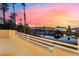 Balcony view overlooking pond, waterfall feature, palm trees and neighborhood homes against a colorful sunset sky at 2221 Glenbrook Way, Las Vegas, NV 89117