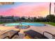 Relaxing backyard retreat featuring a refreshing pool, spa, and comfortable lounge chairs under a vibrant sky at 2221 Glenbrook Way, Las Vegas, NV 89117