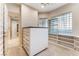 Spacious walk-in closet featuring custom shelving, drawers, carpet, and a unique glass block window for natural light at 2221 Glenbrook Way, Las Vegas, NV 89117