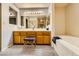 Bathroom featuring dual sinks, oak cabinets, and a soaking tub at 2611 Laguna Shores Ln, Las Vegas, NV 89121