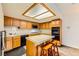 Well-lit kitchen features wood cabinets, appliances, an island with bar seating, and a light panel ceiling at 2611 Laguna Shores Ln, Las Vegas, NV 89121