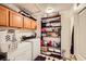 Functional laundry room featuring washer, dryer, shelving, and storage cabinets at 2611 Laguna Shores Ln, Las Vegas, NV 89121