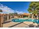 Inviting community pool with a tiled deck, lounge chairs, and a shaded pergola perfect for relaxation at 2611 Laguna Shores Ln, Las Vegas, NV 89121