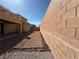 Large backyard offers low-maintenance gravel landscaping, bordered by a high brick wall for added privacy at 2628 Park Hyatt Ave, North Las Vegas, NV 89081