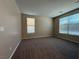Spacious bedroom with carpet flooring, two windows, and neutral paint colors at 2628 Park Hyatt Ave, North Las Vegas, NV 89081