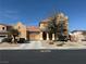 Two-story stucco home featuring a red tile roof, arched entryway, desert landscaping, and two-car garage at 2628 Park Hyatt Ave, North Las Vegas, NV 89081