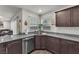 Kitchen featuring stainless appliances, granite countertops, dark cabinets, and hard surface floors at 2682 Weathered Copper Ave, North Las Vegas, NV 89086