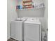The laundry room has a new washer and dryer and shelves for organized storage at 2682 Weathered Copper Ave, North Las Vegas, NV 89086