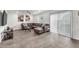 Spacious living room with hard surface flooring, ceiling fan, and large leather couch at 2682 Weathered Copper Ave, North Las Vegas, NV 89086