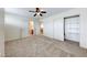 Large bedroom with carpeted floor, ceiling fan and access to the bathroom and hallway at 2752 Drummossie Dr, Henderson, NV 89044