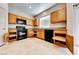 Bright kitchen features granite countertops, tile flooring, wood cabinets, and modern black appliances at 2752 Drummossie Dr, Henderson, NV 89044