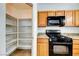 Kitchen featuring a pantry, black appliances, and wooden cabinets at 2752 Drummossie Dr, Henderson, NV 89044