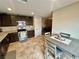 Modern kitchen features dark wood cabinets, stainless steel appliances, granite countertops, and dining area at 2790 Chetco River St, Laughlin, NV 89029