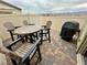 Outdoor patio with pavers, equipped with a round table, four chairs, and a grill, perfect for entertaining at 2790 Chetco River St, Laughlin, NV 89029
