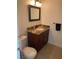 Bathroom with granite counters, wood cabinets, vanity mirror, and a white porcelain toilet at 3417 Iberia St, Las Vegas, NV 89146