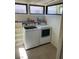 Bright laundry room with a washer, dryer, tile flooring, and a shelf for storage and organizing supplies at 3417 Iberia St, Las Vegas, NV 89146