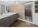Modern bathroom featuring double sinks, a large mirror, walk-in shower, and stone floor at 350 Loma Marsh Ct, North Las Vegas, NV 89084