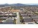 An aerial view features a neighborhood near a school with an athletic field and mountains in the background at 370 Mano Destra Ln, Henderson, NV 89011