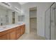 Bright bathroom with double sinks, a large mirror, and a glass-enclosed shower at 370 Mano Destra Ln, Henderson, NV 89011